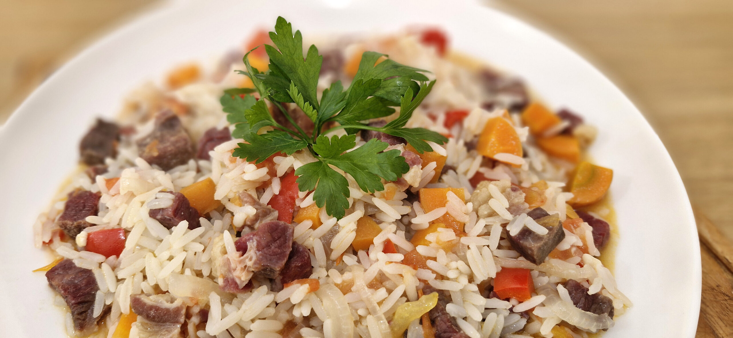 Imagem de um prato de Arroz Maria Isabel servido em uma travessa, decorado com salsinha picada e acompanhado por pimentões coloridos.