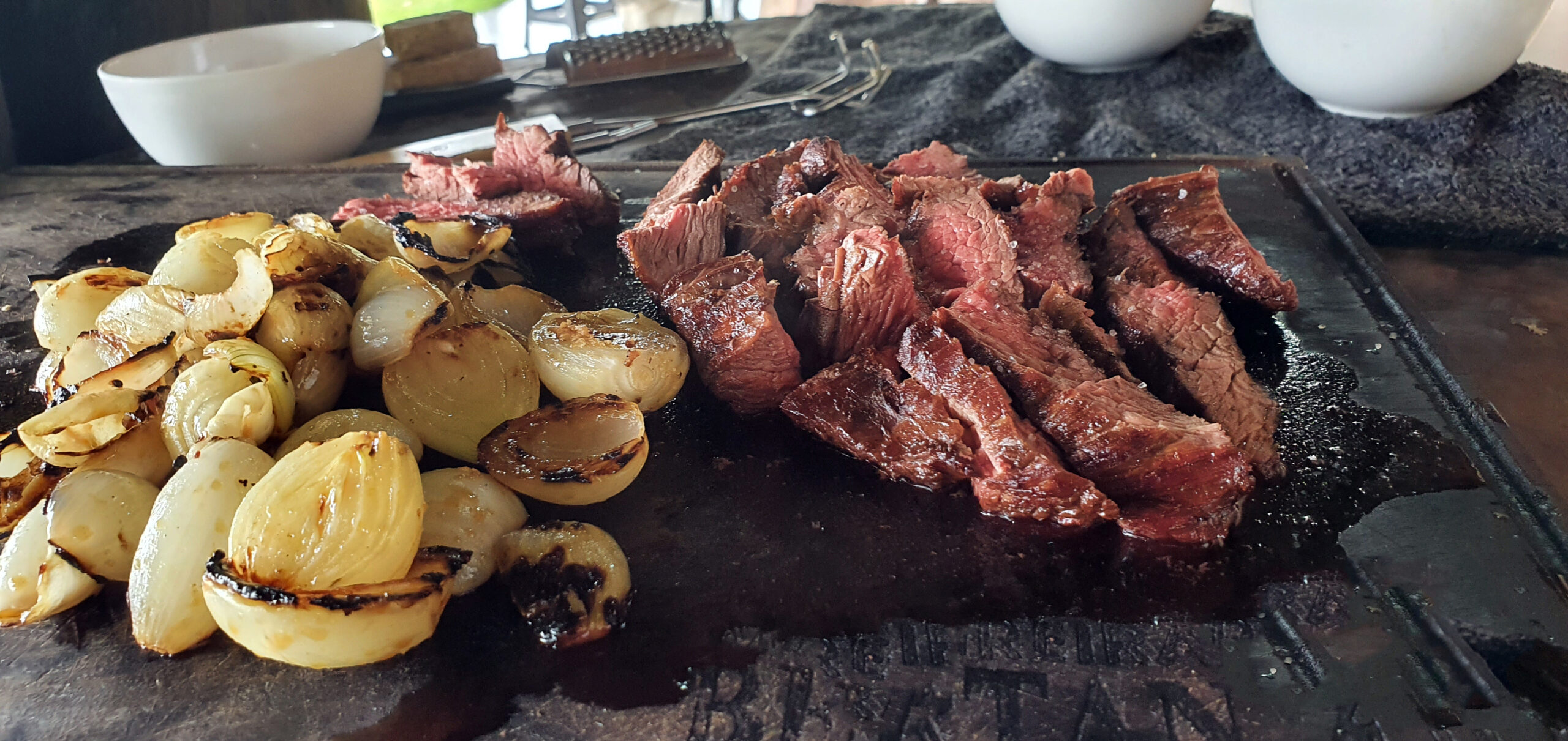 Imagem de fraldinha grelhada e suculenta, acompanhada de cebolas caramelizadas na rapadura.