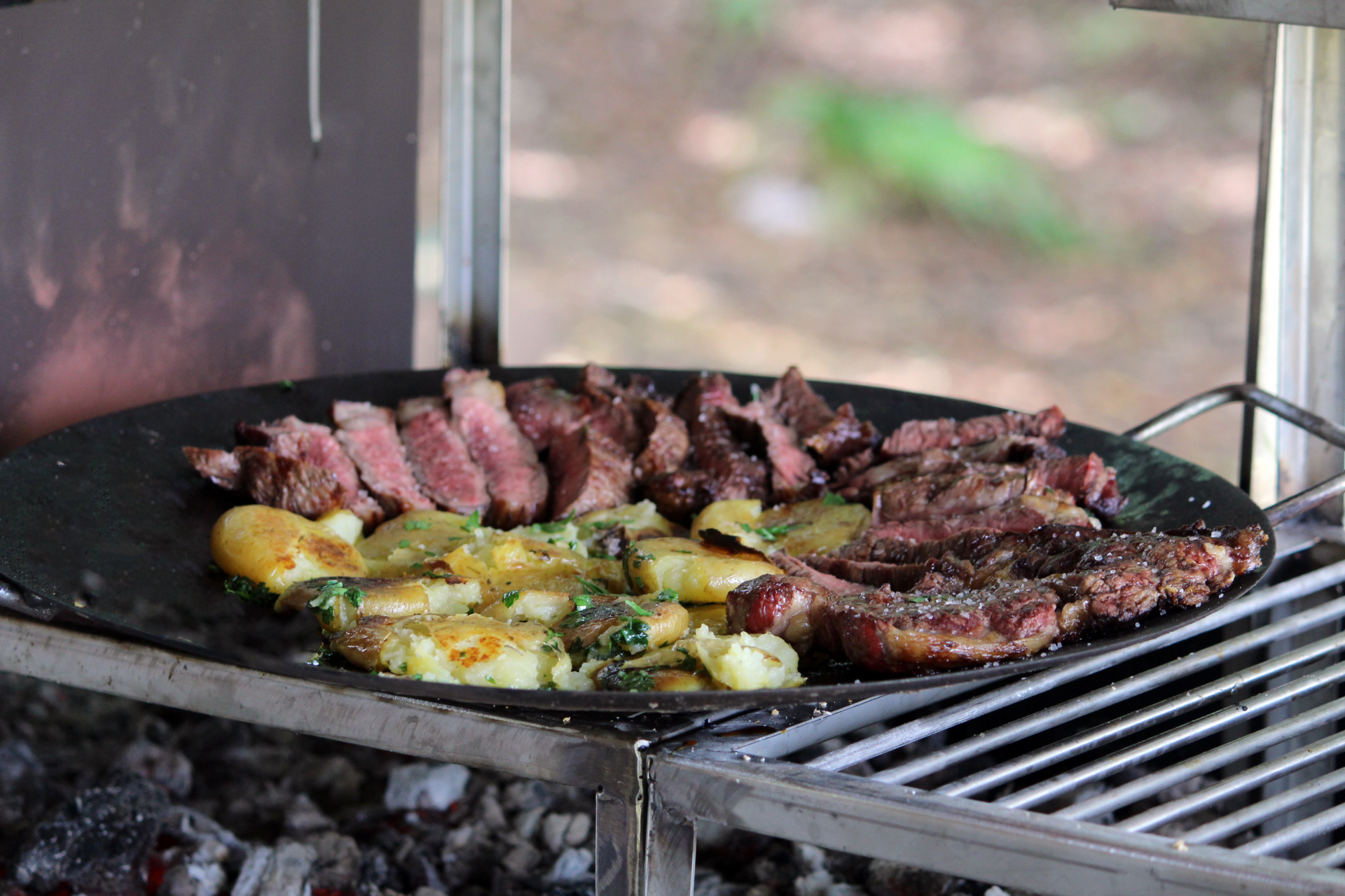 Imagem de contra-filé grelhado suculento, servido com batatas ao murro douradas e temperadas.