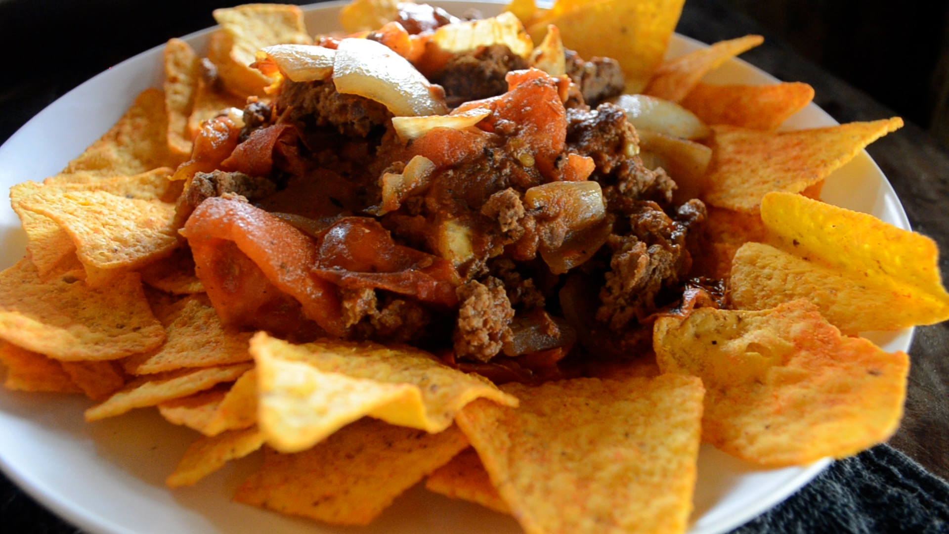 Prato de Chile de Carne com nachos e sanduíche de pão ciabatta, preparado na parrilla.