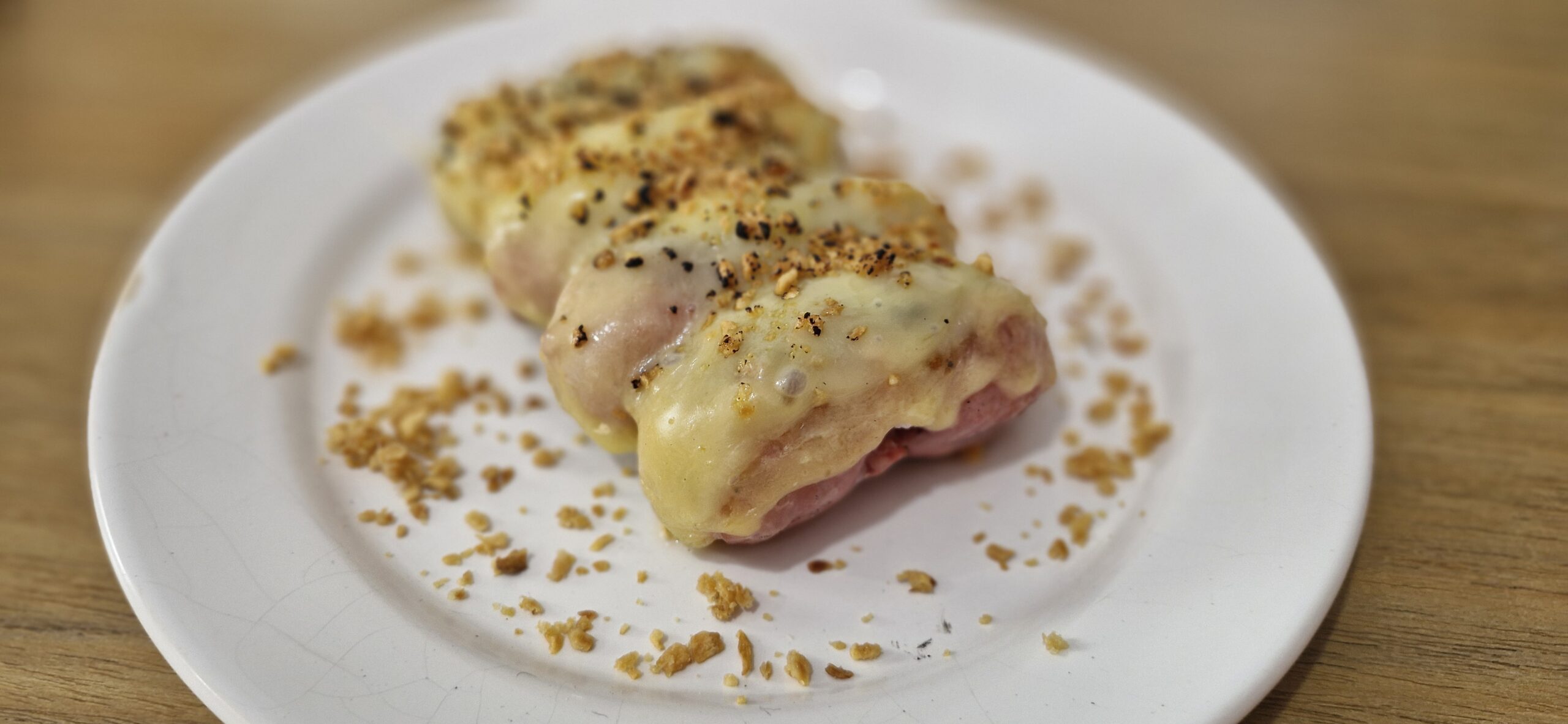 Linguiça toscana assada na churrasqueira com queijo derretido e alho crocante, servida em uma tábua de madeira.
