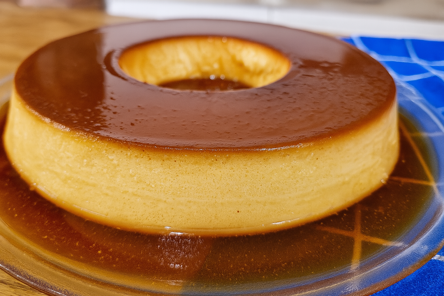 Pudim de milho cremoso servido com calda caramelizada em prato branco