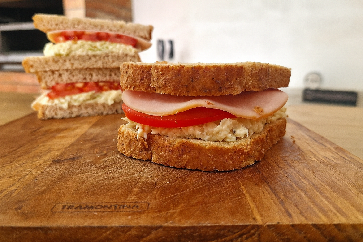Sanduíche natural de ricota e peito de peru no pão integral cortado ao meio