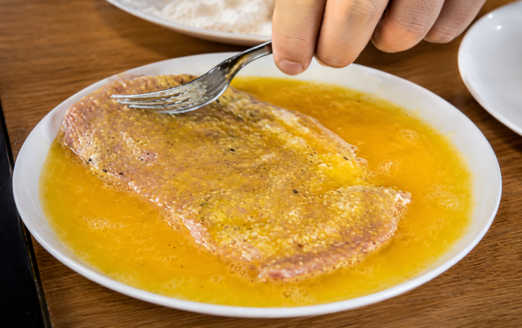 empanando-o-schnitzel-1024x643 Schnitzel Suíno: O Clássico Bife Empanado Alemão Crocante e Suculento