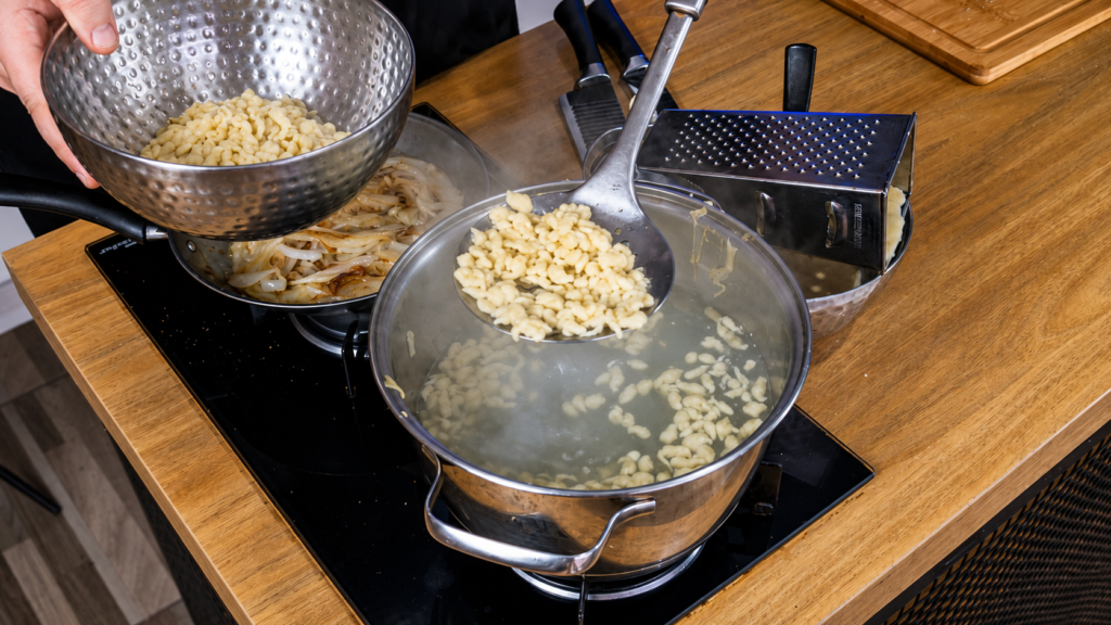 kasespatzle-austriaco-cozido-1024x576 Käsespätzle Austríaco: Massa Caseira com Queijo e Cebola Dourada
